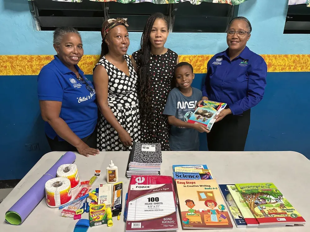 Members presenting textbooks and school supplies